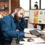 Exhausted businessman holds his forehead